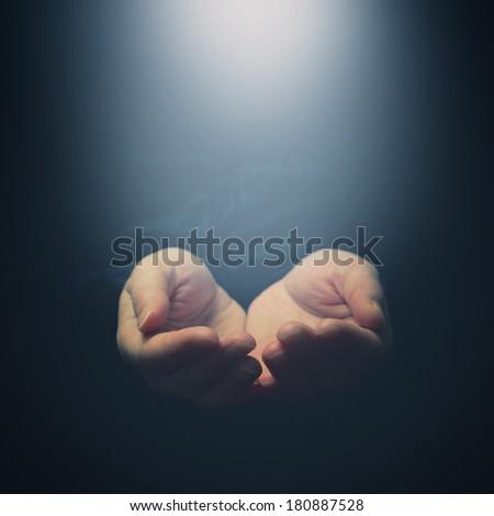 Female hands opening to light. Holding, giving, showing concept. Selective focus on fingers.