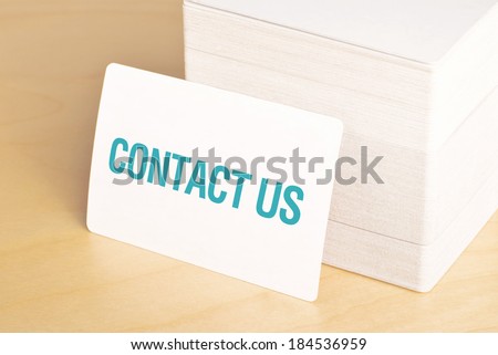 Contact us Business cards with rounded corners. Stack of horizontal business cards propped up another.