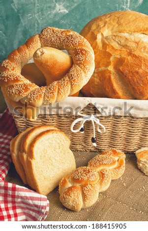 Bread and other baked goods in wicker basket on kitchen table