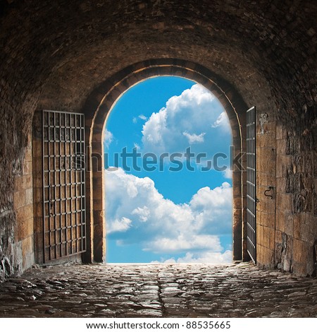 Heaven\'s gate. Dark tunnel corridor with arch opening to a beautiful cloudy sky. Light at the end of the tunnel.