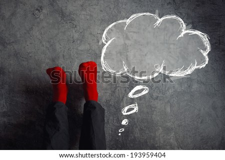 Legs up the wall, putting feet up with think balloon. Man wearing red socks in relaxing yoga pose with his legs on the wall.