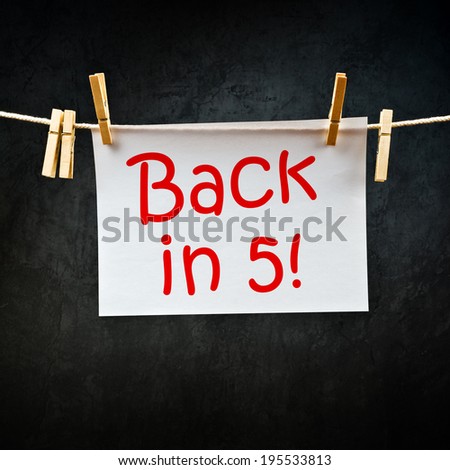 Back in five message printed on paper and hanged on rope with clothes pins.