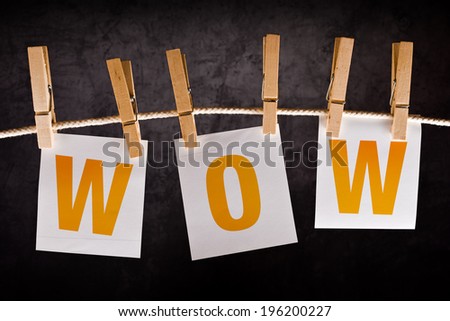 WOW concept. Word WOW printed on notes paper hanging on ropes.
