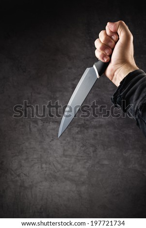 Adult male hand with large sharp knife stabbing