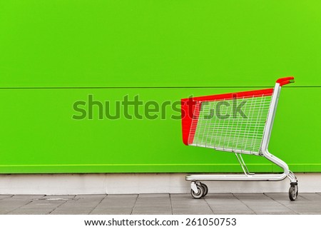 Empty Shopping Cart Trolley in front of Shopping Mall with Blank Copy Space as Consumerism Concept Background.