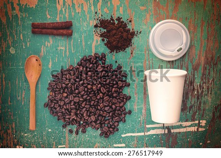 Coffee Break Top View Vintage Toned Concept with Roasted Coffee Beans, Ground, Spoon, Plastic Cup and Cinnamon Sticks on Rustic Wood Background, Retro Toned