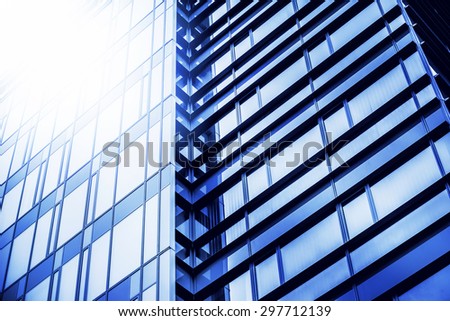 Modern Business Office Building with Glass Windows in Repeating Pattern, Blue Glass Facade with Geometric Lines, Sunlight Reflecting