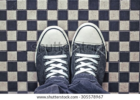Gray Sneakers on Checkered Pattern Pavement, Top View, Overhead Shot of Man Standing on Street, Urban Lifestyle Concept