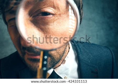 Enlarged eye of tax inspector and financial auditor looking through magnifying glass, inspecting offshore company financial papers, documents and reports. Professional financial forensics concept. Stock foto © 