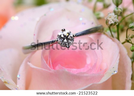 A diamond ring put on pink rose.