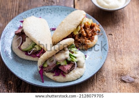Steamed bao buns with beef steaak, pickled cucumber, erd cabbage and mustard mayo Stock fotó © 