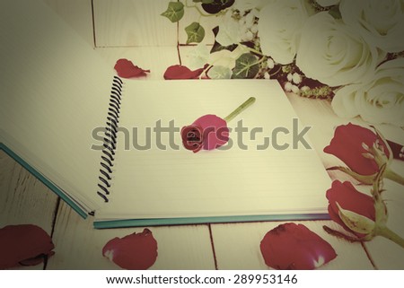 Vintage style - Red rose flower and Notepad book on wood texture.