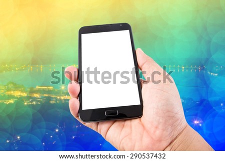 Man hand hold blank touch screen smart phone on abstract blurred bokeh of city night light background.