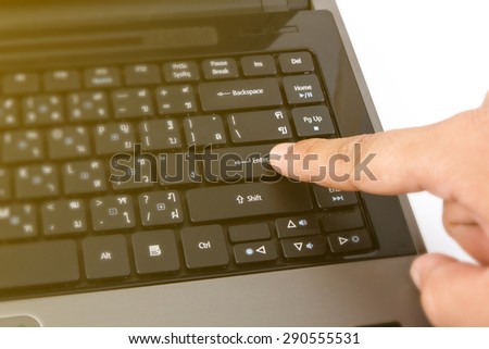 Close-up of Man finger pushing the button of laptop keyboard.