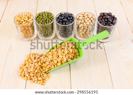 a lot of black bean, green beans, soybean, roasted coffee beans on wood background