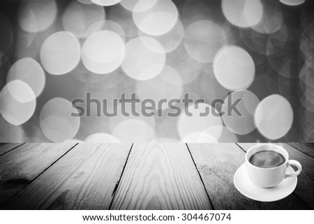 Abstract black and white bokeh of light and coffee cup and wood background
