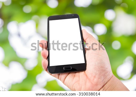 Man hand hold blank touch screen smart phone on Soft green natural bokeh background
