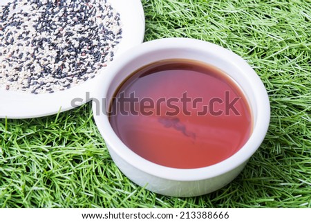 sesame oil seeds and sesame seeds on grass background