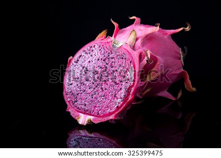 Fresh red dragon fruit with cut dragon fruit and slice on black background