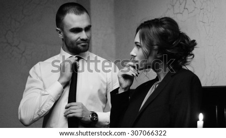 man and woman(girl/lady). man dressed in black suit. woman in dress. They love each other. love story. pre wedding shooting. Models in black, white and red. romance. relation. mirror . luxury