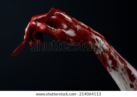 Bloody hand with a scalpel, a nail, black background, zombie, demon, maniac