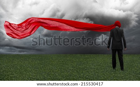 Man in a black suit with a red cloth is in the green field, loneliness, dreams, sleep, red fabric, storm clouds