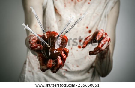 Social advertising and the fight against drug addiction: bloody hands addict holding syringe and bloody human heart