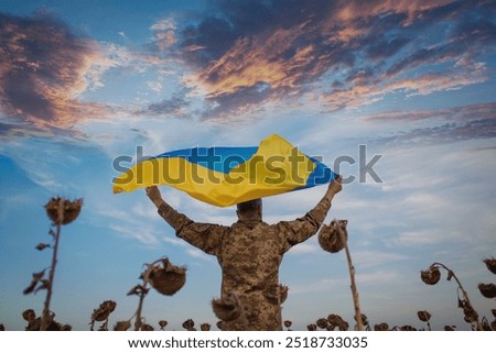 Similar – Foto Bild Soldat der ukrainischen Streitkräfte steht mit einer blau-gelben Flagge der Ukraine auf schwarzem Hintergrund