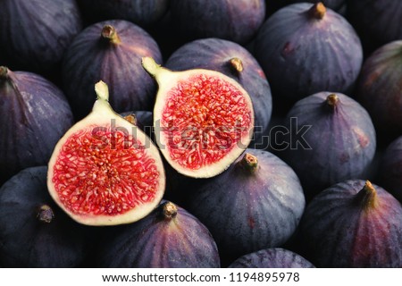 Ripe figs cut on a pink background. Minimal flat lay.