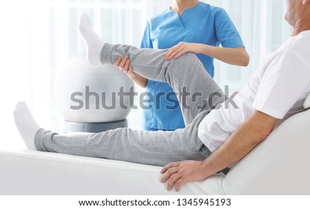 Similar – Image, Stock Photo Physiotherapist stretching leg of patient in medical room