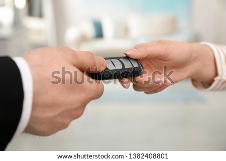 Man and woman holding car smart key indoors, closeup