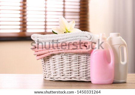 Basket with towels and detergents on table in room Foto stock © 