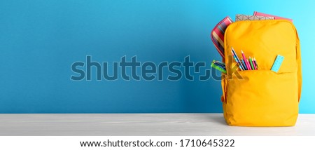 Backpack with different colorful stationery on table. Banner design Сток-фото © 
