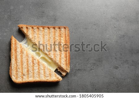 Tasty toast sandwiches with cheese on grey table, top view. Space for text