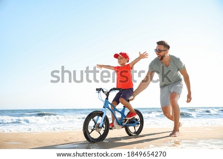 Similar – Image, Stock Photo Man cycling on sandy beach hill