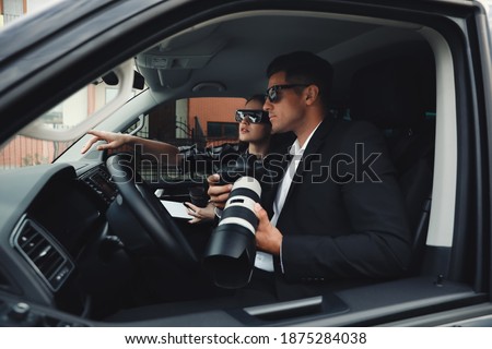 Private detectives with modern camera spying from car Foto stock © 