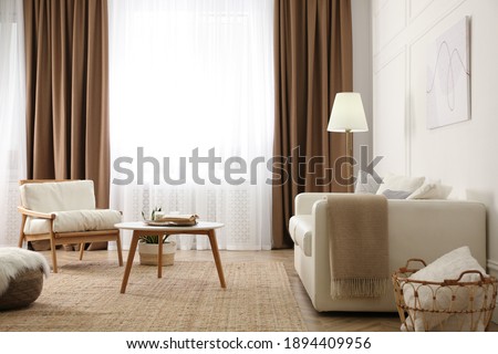 Modern furniture and window with curtains in stylish room interior