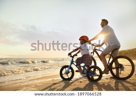 Similar – Image, Stock Photo Man cycling on sandy beach hill