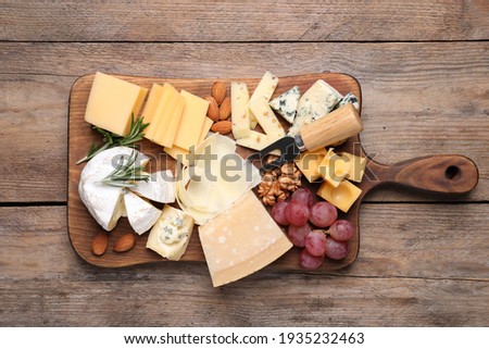 Cheese plate with grapes and nuts on wooden table, top view Foto stock © 