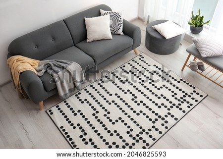 Living room interior with comfortable sofa and stylish rug, above view