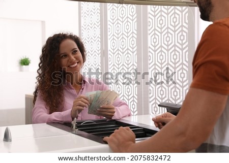 African American cashier counting money at cash department window in bank. Currency exchange Stock foto © 
