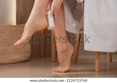 Woman using pumice stone for removing dead skin from feet indoors, closeup Stock fotó © 