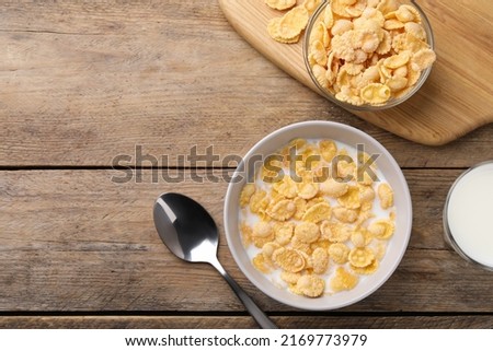 Foto Bild Frische Cornflakes, serviert mit Erdbeeren und Blaubeeren auf einem blauen Holztisch