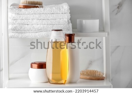 Stack of towels, brushes, shampoo and other toiletries on shelves near white marble wall ストックフォト © 