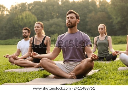 Image, Stock Photo Adult people practicing yoga together in balance pose and stretching body in light contemporary studio