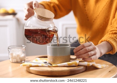 Similar – Image, Stock Photo Woman pouring green tea in mug on wooden table with green herb