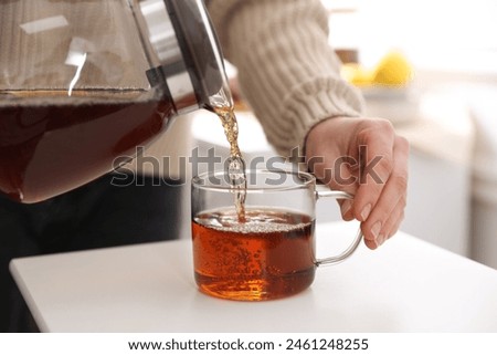 Similar – Image, Stock Photo Woman pouring green tea in mug on wooden table with green herb