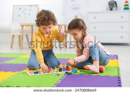 Similar – Image, Stock Photo Toddler playing with a colorful plastic bug toy; using hands to manipulate small object developmental milestone