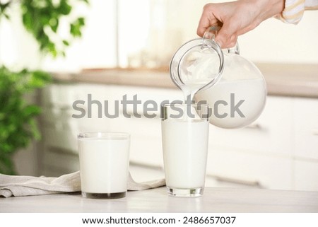 Similar – Image, Stock Photo Woman pouring fresh milk from bottle to enamel mug while having refreshment in garden