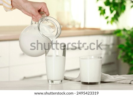 Similar – Image, Stock Photo Woman pouring fresh milk from bottle to enamel mug while having refreshment in garden